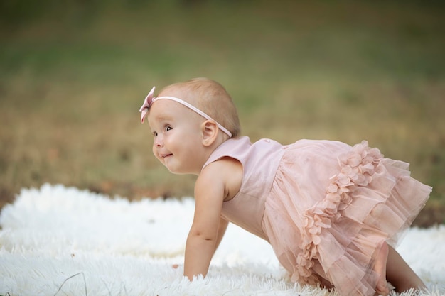 Funny little girl on a walk in a summer park One year old child Sweet baby