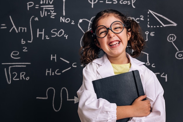 Funny little scientist laughing with a notebook