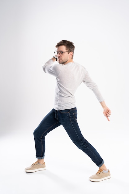 Funny man  in casual t-shirt and jeans jumping isolated over white background