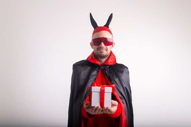 Funny man in halloween costume and giftbox isolated on white.