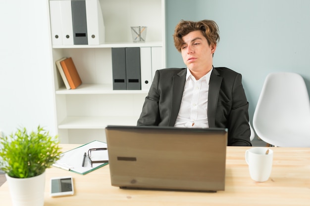 Funny man tired after working on computer in office