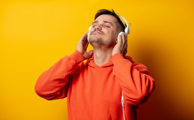 Funny man with headphones on yellow wall