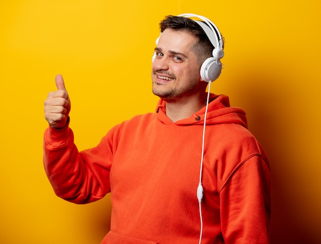 Funny man with headphones on yellow wall