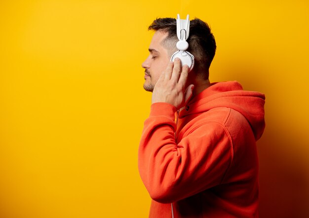 Funny man with headphones on yellow wall