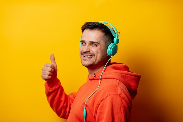 Funny man with headphones on yellow wall