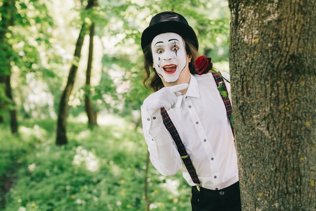 Funny mime next to a tree