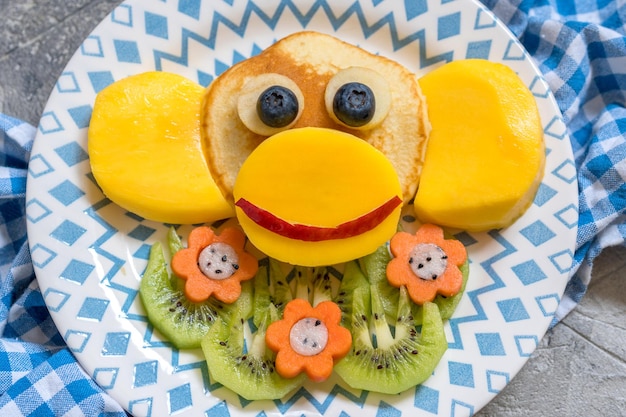 Funny monkey pancakes with fruits for kids breakfast