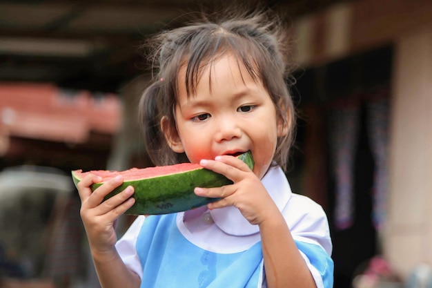 Funny portrait of an incredibly beautiful little girl eating watermelon, healthy fruit snack