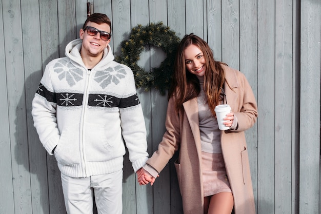 Funny smiling couple in love posing on the street in winter cold weather