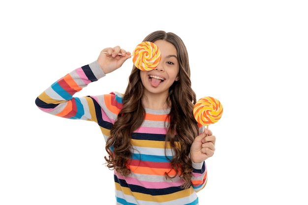 Funny teen girl in colorful sweater with lollipop candy on stick isolated on white background, caramel shop.