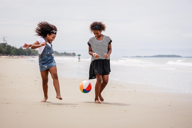 Funny vacation Children or kids playing ball and having fun on a tropical beach