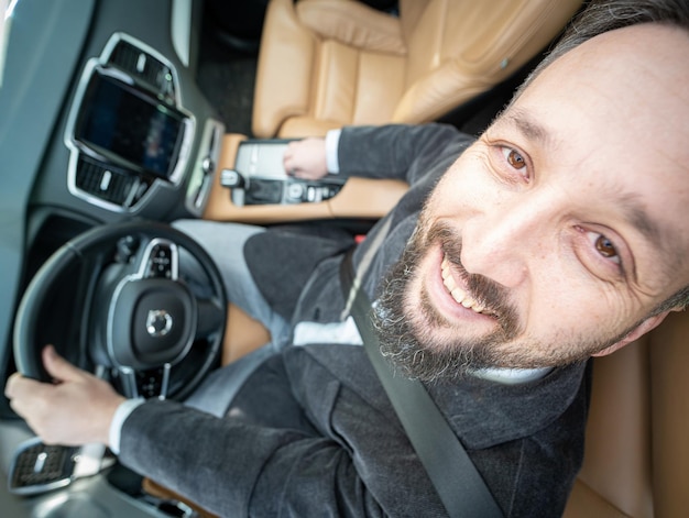 Funny wide angle of a male driver in luxury car