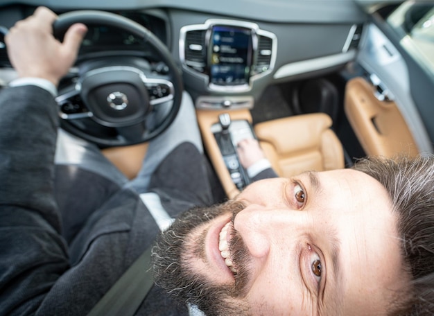 Funny wide angle of a male driver in luxury car