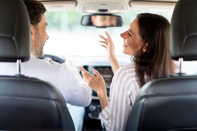 Funny woman entertaining her husband while going car trip together