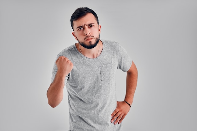 Furious outraged caucasian man threaten in anger, frowns his face, keeps fists, going to defend himself in fight. Desperate european guy shows his power, clenches fists. People Emotions Business