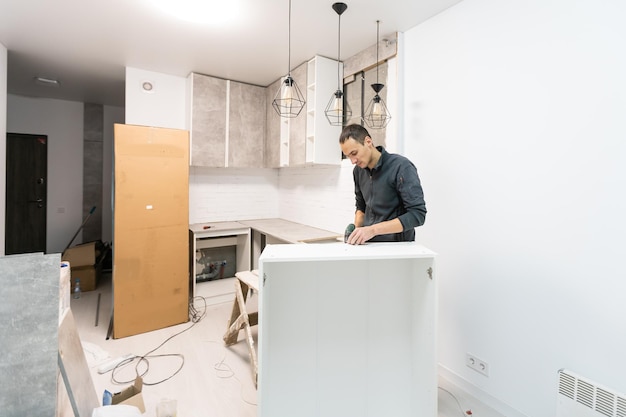 furniture assembly - worker installing cabinet shelf.