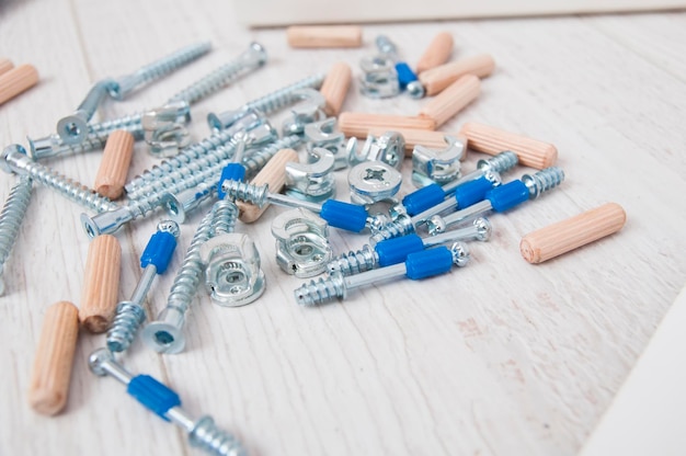 Furniture fasteners screws and dowels in a pile close up