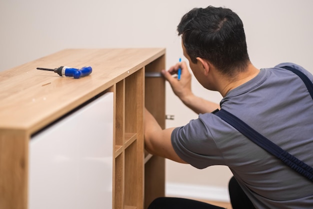 Furniture manufacturing and fixing carpenter hands installing shelves to wooden furniture