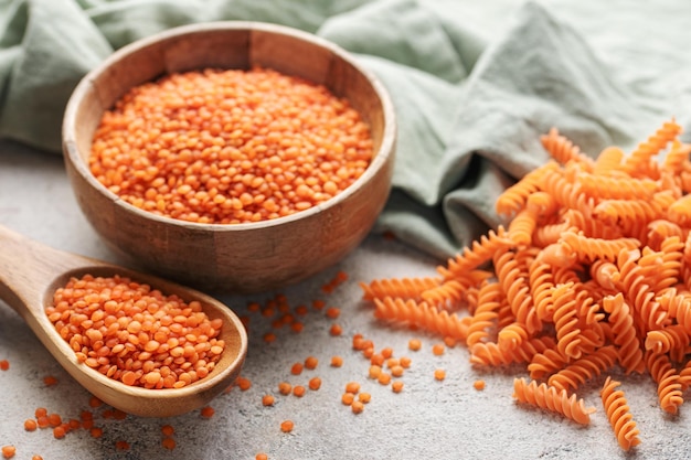 Fusilli red lentil pasta on a gray concrete background