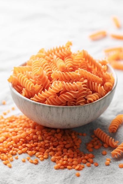 Fusilli red lentil pasta on a gray textile background