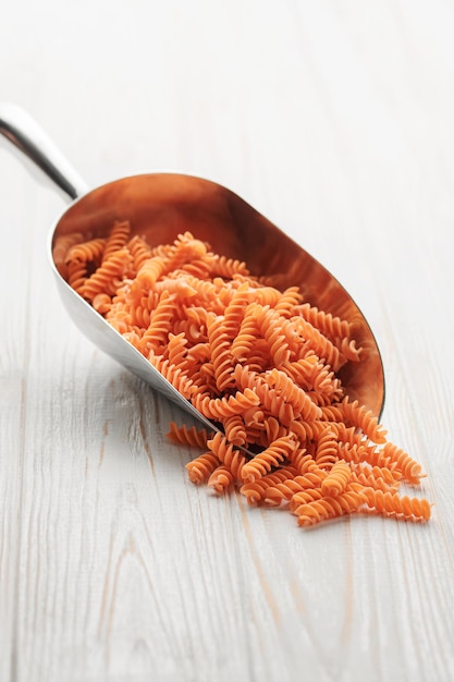 Fusilli red lentil pasta on a wooden background