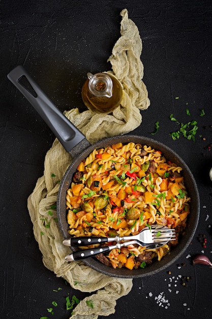 Fusilli vegetable paste with pumpkin, Brussels sprouts, paprika and liver pieces. View from above