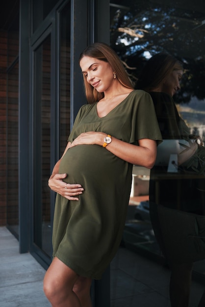 Future smile and a pregnant woman on an office balcony for business waiting to be a mother Stomach pregnancy and happy young employee at the workplace as an employee thinking about maternity leave