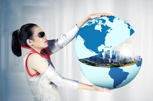 Futuristic woman showing a modern city on the globe