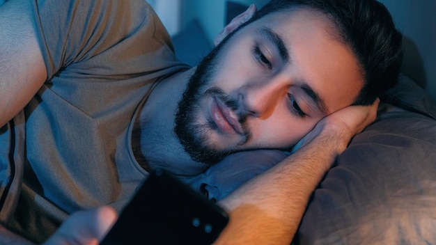 Gadget night late online man using phone in bed