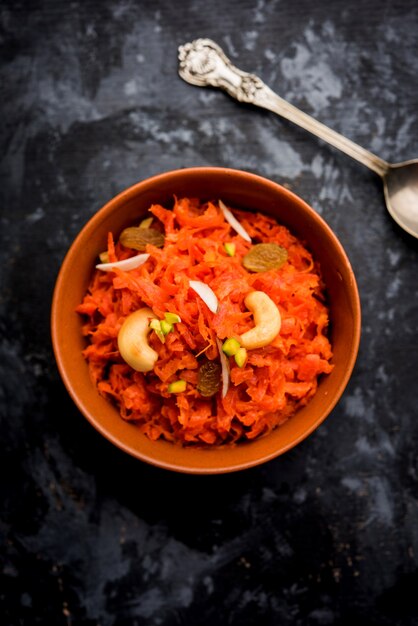 Photo gajar ka halwa is a carrot-based sweet dessert pudding from india. garnished with cashew almond nuts. served in a bowl.