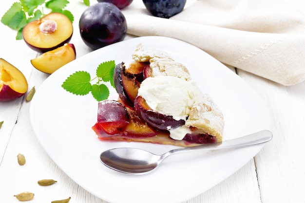 Galeta with plums in plate on wooden board