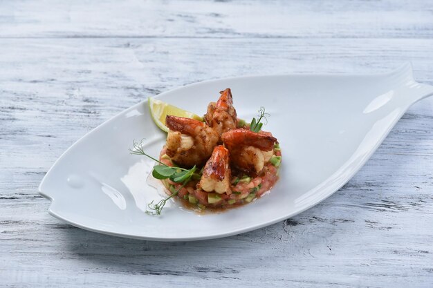 Gambas shrimp with vegetable tartare, seafood dish, photo for menu, top view