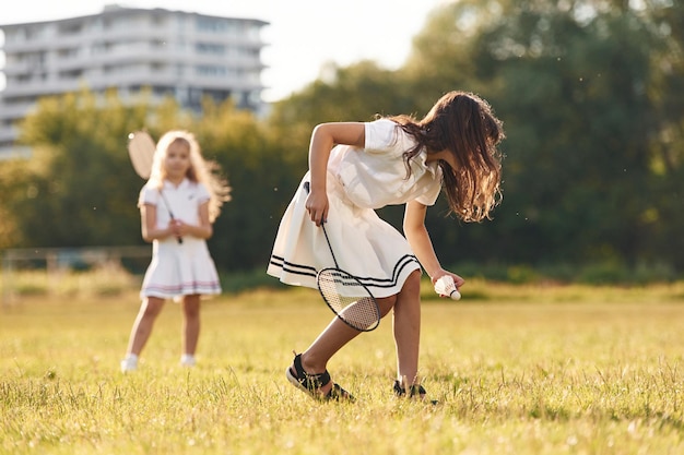 Photo game of badminton happy kids are on the summer field