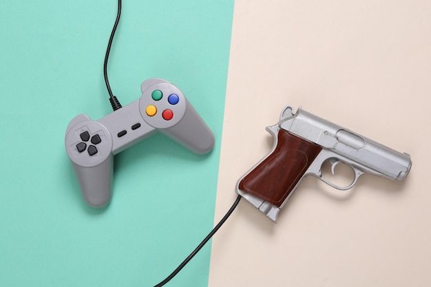 Gamepad and video game gun on mint green beige background Gaming concept Top view