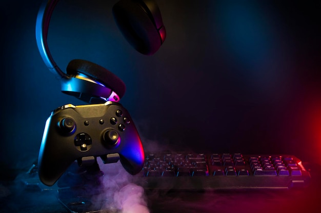 Gamer devices for playing game by joystick with computer headphone and mouse on neon glow, gaming and esports challenge, streaming online, tournament concept