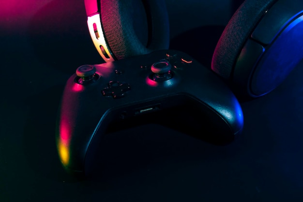 Gamer playing the online game with joystick controller in neon glow dark cyberpunk room gaming and esports challenge tournament streaming streamer with analog device in living house