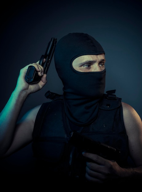 Gangster, terrorist carrying a machine gun and balaclava