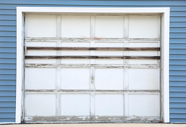 A garage door with a blue tin roof is open.