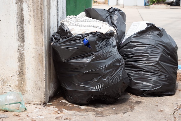 Garbage bag.Garbage bags and recycle green bin. Dumpsters being full with garbage