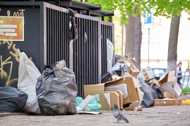 Garbage bins disposal full with litter scattered around on city street