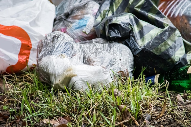 Photo garbage in plastic bags lies on grass environmental pollution ecological problems concept