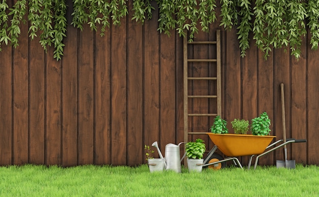 Garden with an old wooden fence and tools for gardening