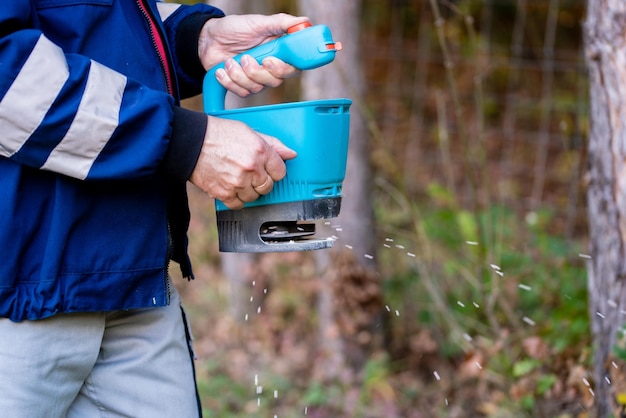 Garden worker in the residential backyard with fertilizing lawn