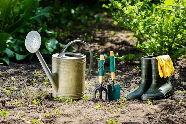 Gardening tools and flowers in the garden such as watering can rubber boots vases pots rubber gloves