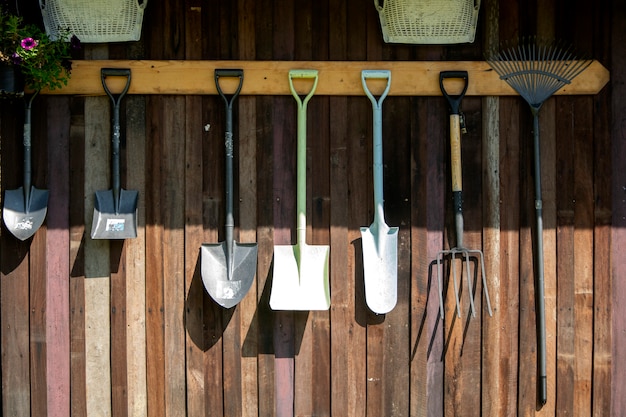 Gardening tools hang on Wooden wall, tools.