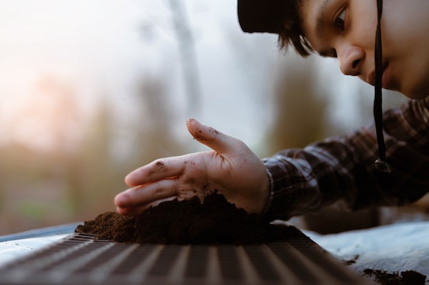 Gardening two hand of a gardener inserting rich black soil t