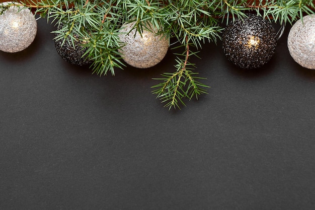 Garland in the form of wicker balls on a dark background with sprig of spruce.