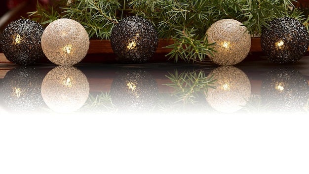 Garland in the form of wicker balls on a white background with a sprig of spruce.