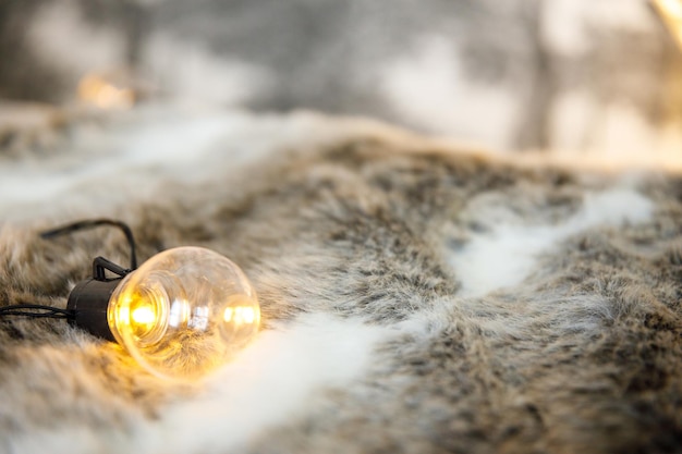 Garland lamps lie on fluffy cozy fur blanket