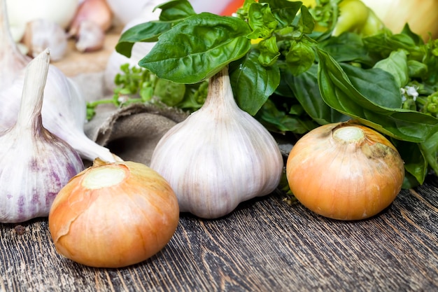 The garlic and Basil green color together with onion during cooking , the kitchen table while cooking the food, close-up